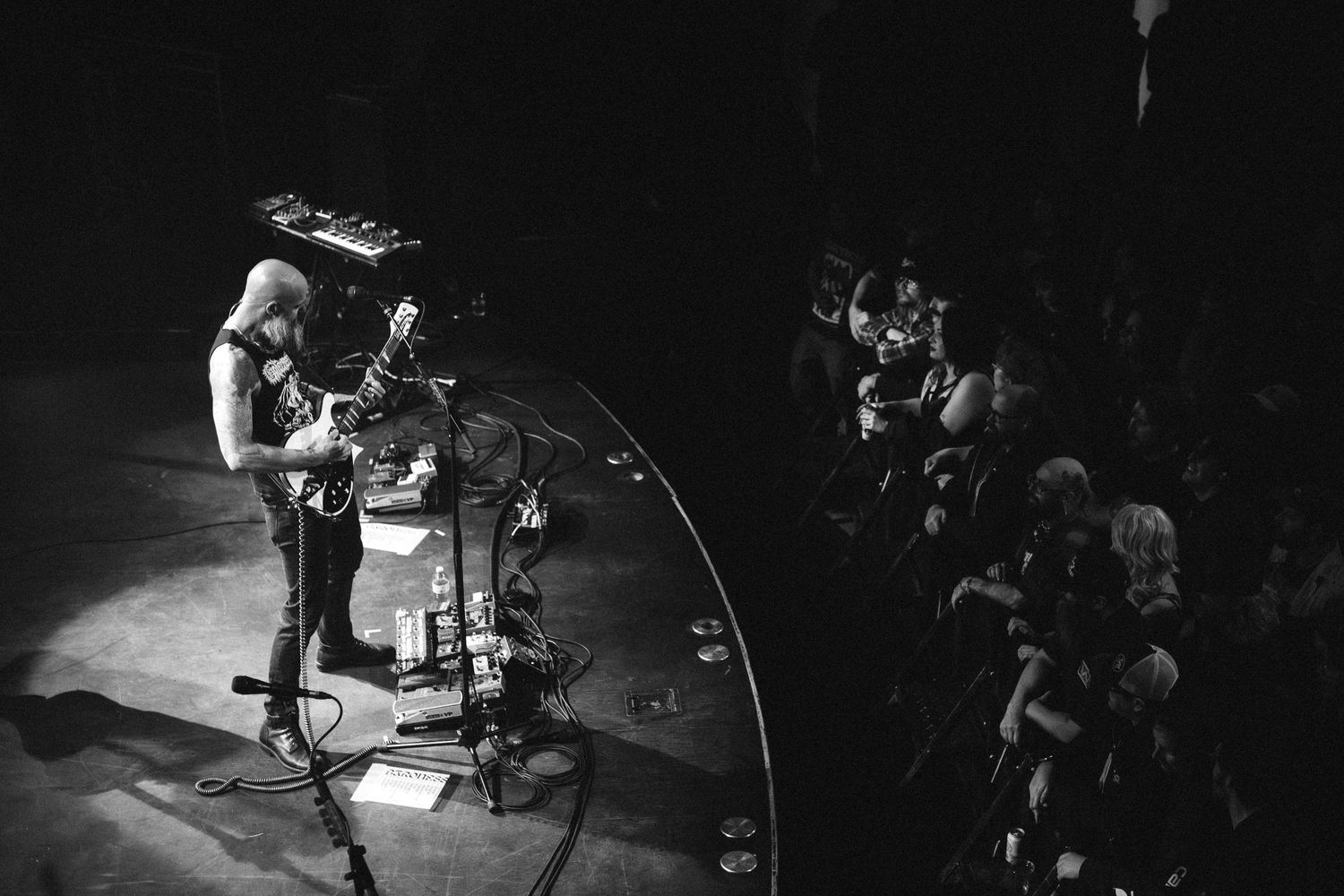 Overhead view of a Baroness guitarist at his pedalboard on the curved stage beside the crowd, The Palace Theatre, Calgary