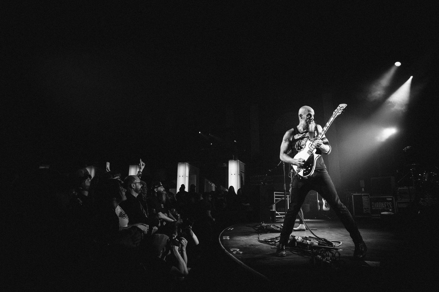 Wide view of a Baroness guitarist in a wide stance under spotlights, the crowd to the left, The Palace Theatre, Calgary