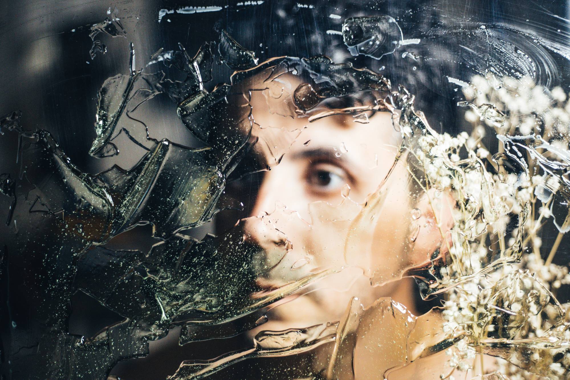 Dario Hudon, photographer and founder of Le Café Studio, in a self-portrait through textured glass with dried flowers