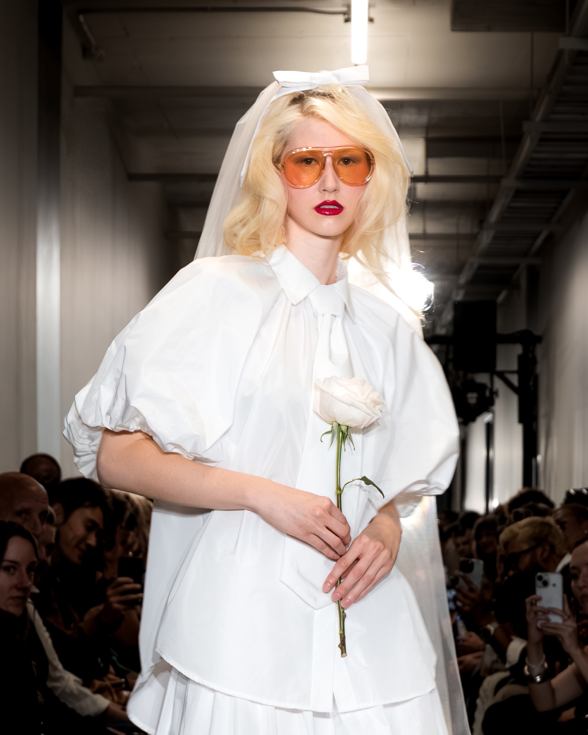 Model Coco on the runway in a white veil, puff-sleeve blouse holding a white rose, Montreal Fashion Week 2025