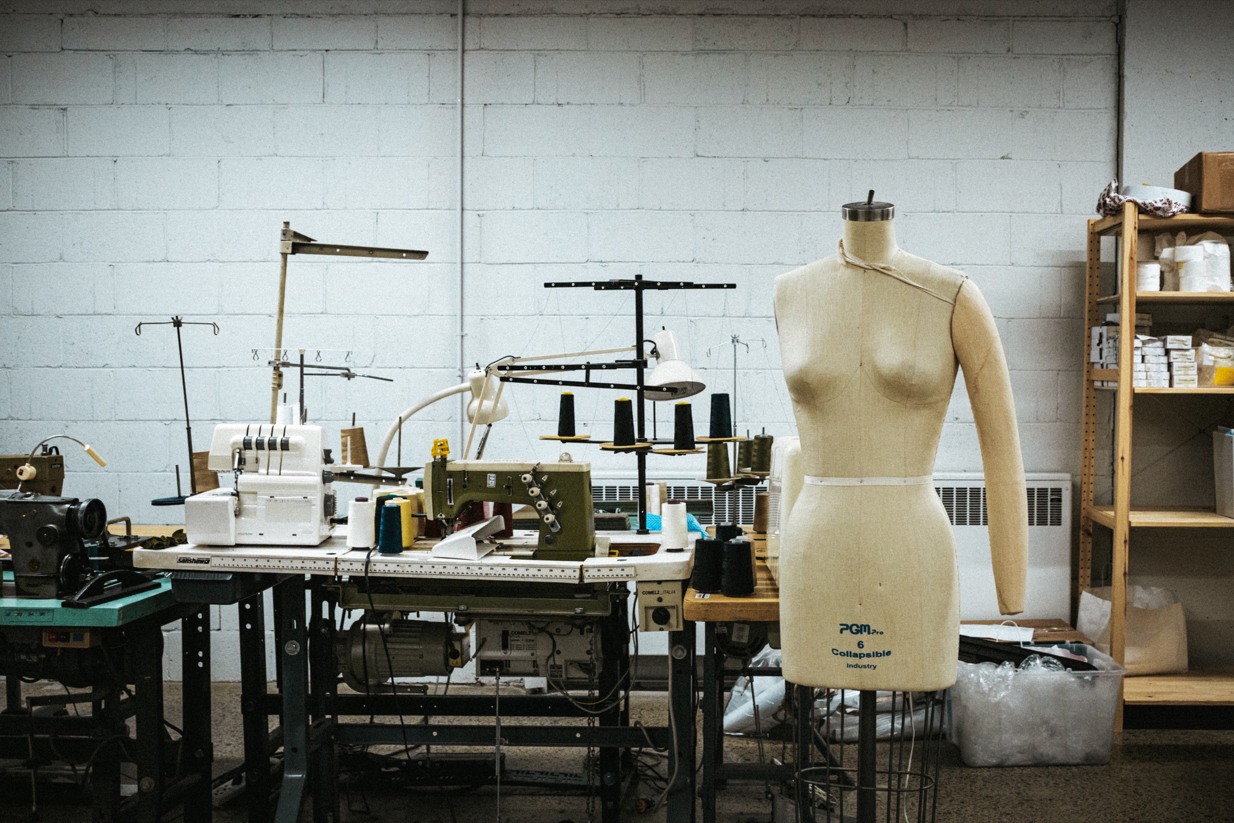 Designer workroom with industrial sewing machines and a dress form, Eliza Faulkner studio, Montreal Fashion Week 2025